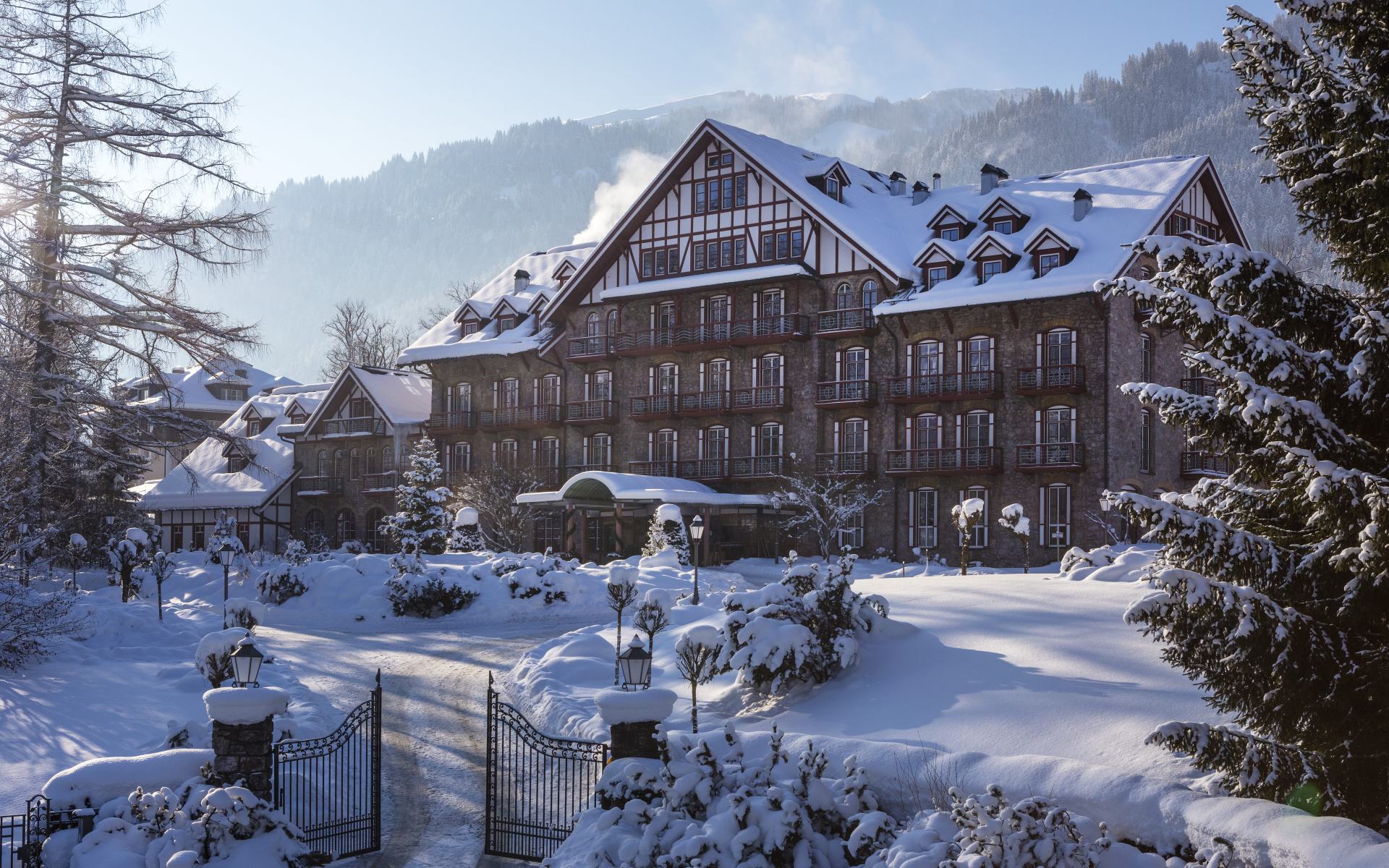 Grand hotel surrounded by snow-covered landscape and trees